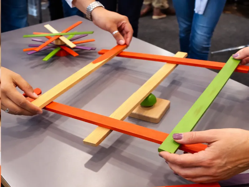 Offene Holzmaterialien mit farbigen Stäben als kreative Spielidee für Familien